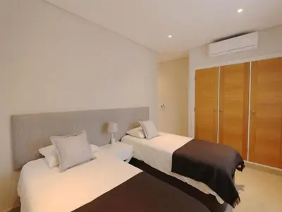 a hotel room with two beds and a closet at Lovely Vilamoura Villa 4 Bedrooms Villa Pinhal Short Drive To Marina in Quarteira