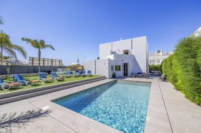 a swimming pool in front of a white house at Villa Casa Morim by Villa Plus in Olhos de Água