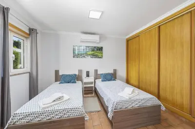 a room with two beds and a closet at Villa Casa Morim by Villa Plus in Olhos de Água