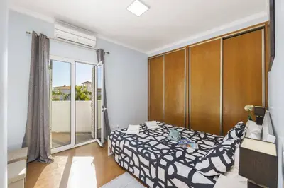a bedroom with a bed and a large window at Villa Casa Morim by Villa Plus in Olhos de Água