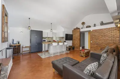 a living room with a couch and a kitchen at Villa Damasco by Villa Plus in Albufeira