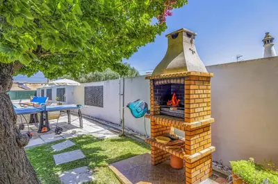 a brick fireplace in the backyard of a house at Villa Damasco by Villa Plus in Albufeira