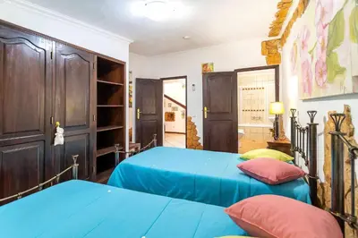 two beds in a room with blue sheets and red pillows at Villa V4 Máximo in Albufeira