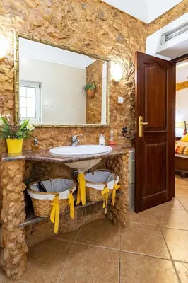 a stone bathroom with a sink and a mirror at Villa V4 Máximo in Albufeira