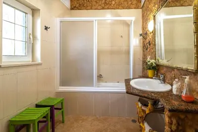 a bathroom with a sink and a window and green stools at Villa V4 Máximo in Albufeira