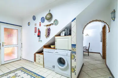 a laundry room with a washer and a staircase at Villa V4 Máximo in Albufeira