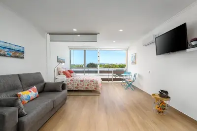a living room with a couch and a bedroom at Apartamento Algarve, located center of Vilamoura in Quarteira