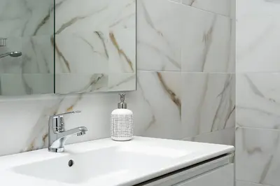 a white bathroom with a sink and a mirror at Apartamento Algarve, located center of Vilamoura in Quarteira
