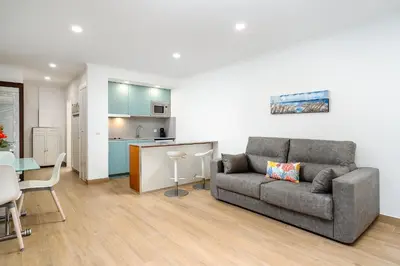 a living room with a couch and a kitchen at Apartamento Algarve, located center of Vilamoura in Quarteira