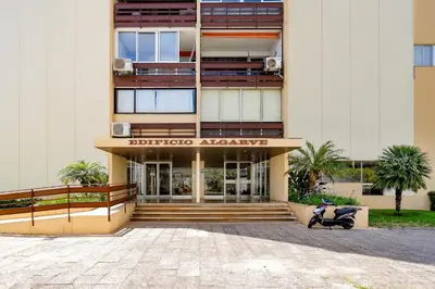 a building with a scooter parked in front of it at Apartamento Algarve, located center of Vilamoura in Quarteira