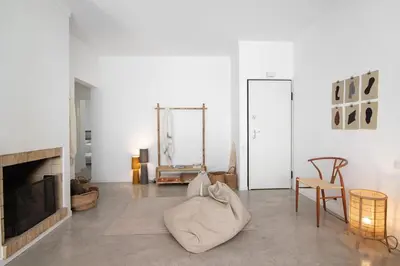 a living room with white walls and a fireplace at Balaia 9 in Olhos de Água