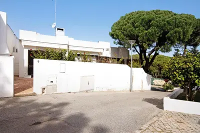 a white wall with a tree in front of a building at Balaia 9 in Olhos de Água