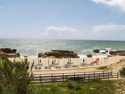 a beach with lounge chairs and the ocean at Casa Francisco : Family Villa with private pool. Near to beach in Albufeira