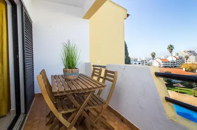 a small wooden table and chairs on a balcony at Apartment OuraVale in Albufeira