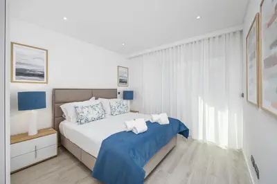 a bedroom with a bed with two towels on it at Terraços de Quarteira Green by Real Properties in Quarteira