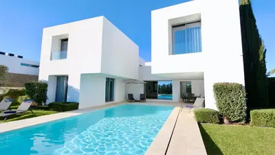 a white house with a swimming pool in front of it at Villa BEA - Clever Details, Luxury, Golf views, Sleeps 10 in Vilamoura