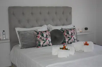 a bedroom with a large bed with white sheets and pillows at Yucca in Faro