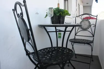 a black chair and a table with a plant at Yucca in Faro