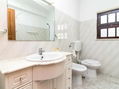 a white bathroom with a sink and a toilet at Villa Dogueno by Stay ici Algarve Holiday Rental in Albufeira