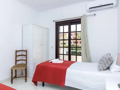 a bedroom with a bed and a chair and a window at Villa Dogueno by Stay ici Algarve Holiday Rental in Albufeira