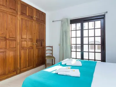 a bedroom with a blue bed and a window at Villa Dogueno by Stay ici Algarve Holiday Rental in Albufeira