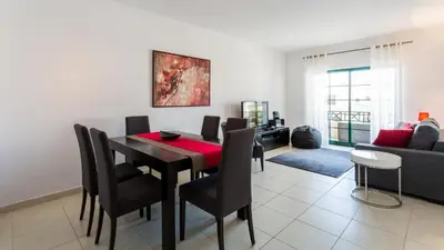 a dining room with a table and chairs and a couch at Central Albufeira 2-B Apt Sleeps 6 Pool Parking in Areias Sao Joao