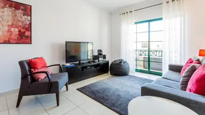 a living room with a couch and a tv at Central Albufeira 2-B Apt Sleeps 6 Pool Parking in Areias Sao Joao