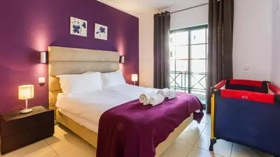 a bedroom with a bed with towels on a table at Central Albufeira 2-B Apt Sleeps 6 Pool Parking in Areias Sao Joao