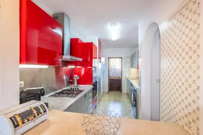 a kitchen with red cabinets and a counter top at Apartment Luna - Resort with a pool area with a lounge bar in Albufeira