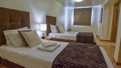 a hotel room with two beds and a window at 8-Bed Villa in Vilamoura-Sleeps-Playground-Pool in Vilamoura