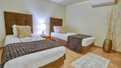 a hotel room with two beds and a vase at 8-Bed Villa in Vilamoura-Sleeps-Playground-Pool in Vilamoura