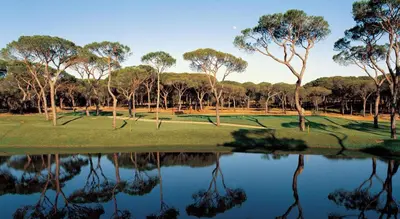 a golf course with trees and a reflection in the water at 8-Bed Villa in Vilamoura-Sleeps-Playground-Pool in Vilamoura