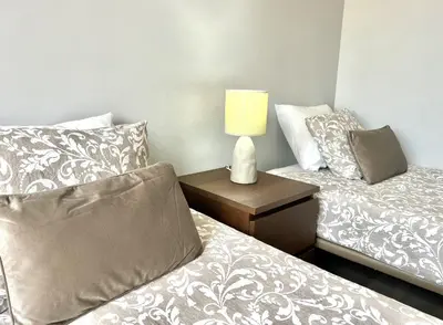 a bedroom with two beds and a table with a lamp at Marina Jardim - Vilamoura Marina by HD Properties in Vilamoura