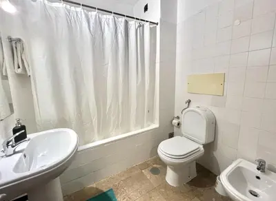 a white bathroom with a toilet and a sink at Marina Jardim - Vilamoura Marina by HD Properties in Vilamoura