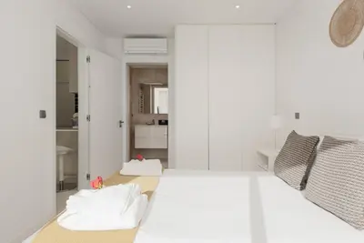 a bedroom with a white bed with two pillows at Terraços de Quarteira Green by Real Properties in Quarteira