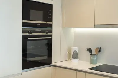 a kitchen with a microwave and a counter top at Terraços de Quarteira Green by Real Properties in Quarteira