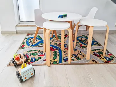 a rug with a table and two stools and a toy car on it at Villa Stefy by Bedzy in Galé
