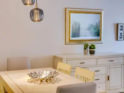 a dining room with a table and chairs and a mirror at AL - Apartamento Carteia in Quarteira