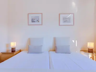 two beds in a white room with two lamps at AL - Apartamento Pinhal da Praia in Vilamoura