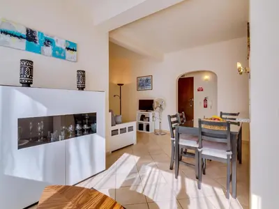 a kitchen and living room with a table and chairs at AL - Apartamento Pinhal da Praia in Vilamoura
