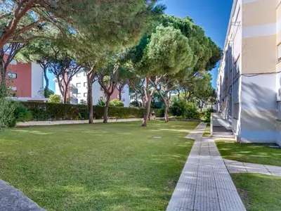 a sidewalk next to a building with trees and grass at AL - Apartamento Pinhal da Praia in Vilamoura