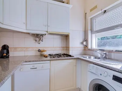 a white kitchen with a sink and a washing machine at AL - Apartamento Pinhal da Praia in Vilamoura