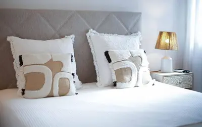 a bedroom with a white bed with pillows and a lamp at Oura 7 in Albufeira