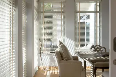 a living room with a chair and a table and windows at Villa Anna - Vale de Lobo in Faro