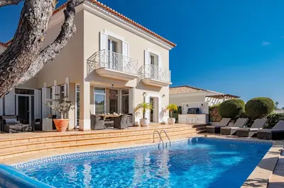 a villa with a swimming pool in front of a house at Villa Anna - Vale de Lobo in Faro