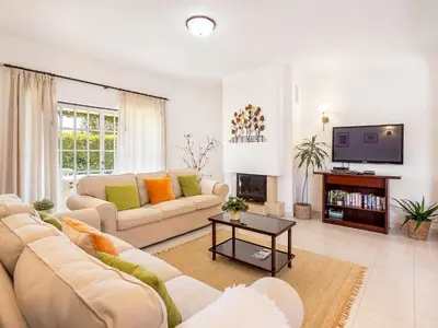 a living room with a couch and a tv at Vila Montejunto in Albufeira