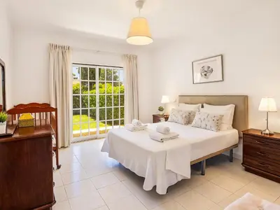 a bedroom with a large white bed with towels on it at Vila Montejunto in Albufeira
