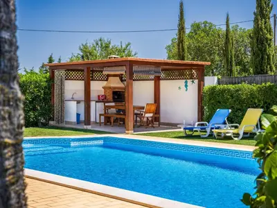 a swimming pool in a yard with a gazebo at Vila Montejunto in Albufeira