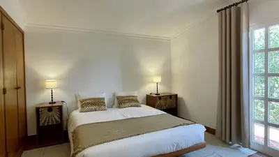 a bedroom with a bed with two night stands and two windows at Espraguina by Check-in Portugal in Loulé