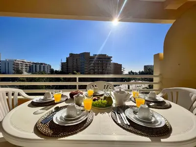 a white table with food and drinks on a balcony at Vilamoura Marina Mar 2 With Pool by Homing in Vilamoura